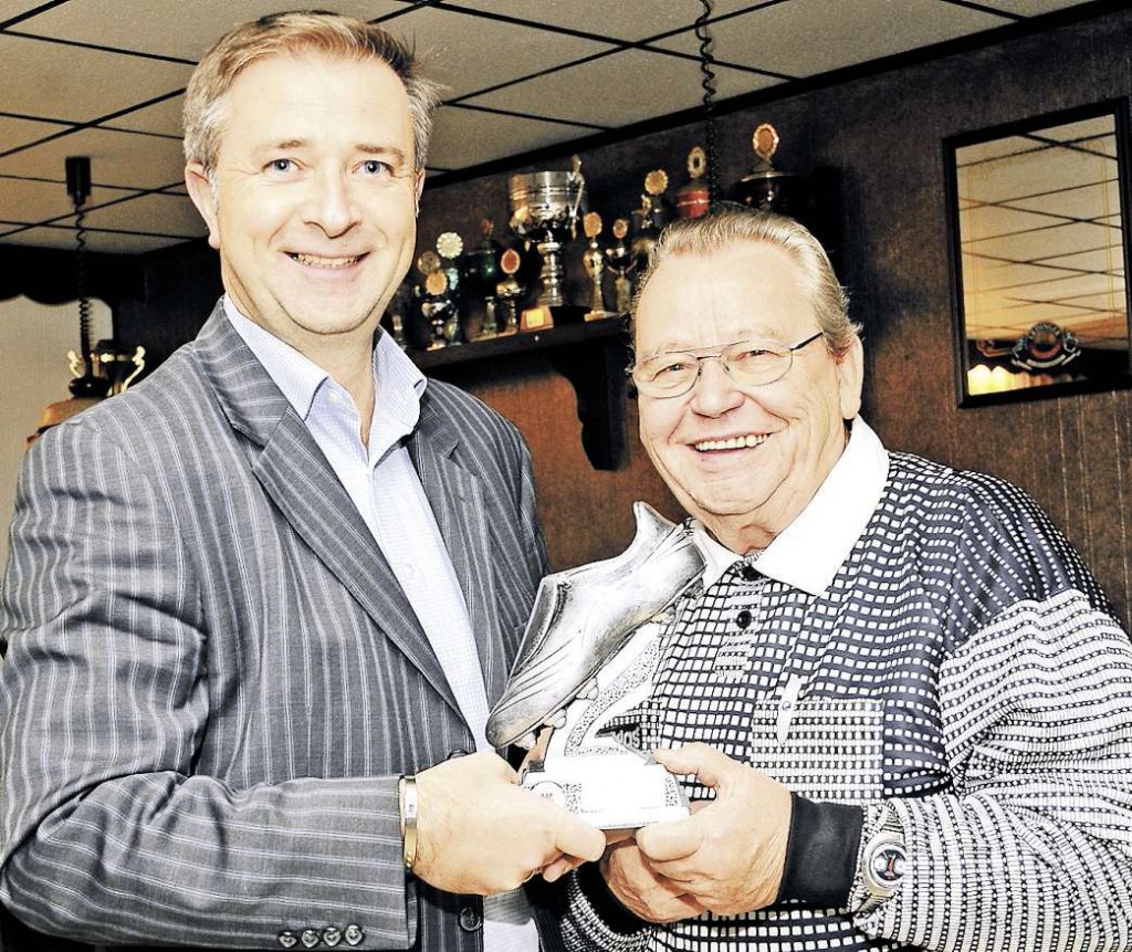 Ehrung für 50-jährige Schiedsrichtertätigkeit: Der Kreisschiedsrichterobmann Marcin Kuczera ehrt Joachim Rustenbeck (rechts) mit dem silbernen Fußballschuh. Foto: Burghard Neumann